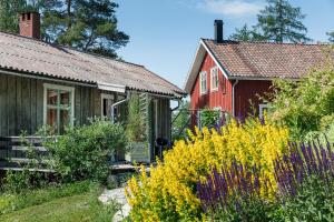 格内斯塔Sustainable and soulful close to lake的一座房子和一座红色的房子,还有一些黄色的花