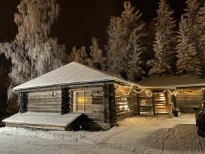 MuurameRiihitulkku Lodge的雪中带圣诞灯的小木屋