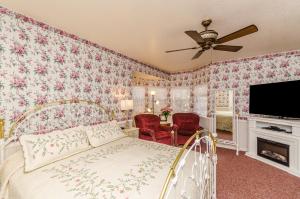 大熊湖Apples Bed and Breakfast Inn的一间卧室配有一张粉红色花卉壁纸的床