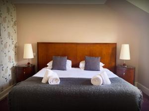 斯佩河畔格兰敦The Speyside Hotel and Restaurant的一间卧室配有一张大床和毛巾