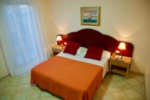 托雷莫泽Hotel Teti的一间卧室配有一张带红色枕头的大床