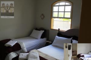 欧鲁普雷图Vila Marias的一间卧室设有两张床和窗户。