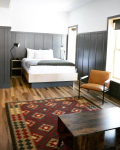 罗斯兰The Flying Steamshovel Inn的卧室配有1张床、1张桌子和1把椅子