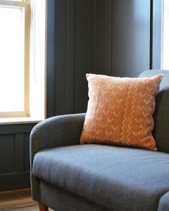 罗斯兰The Flying Steamshovel Inn的客房内的蓝色沙发,配有橙色枕头