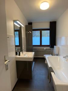 施莱登Villa Holgenbach - Penthouse- und Ferienwohnung im Nationalpark Eifel的浴室配有两个盥洗盆和浴缸。