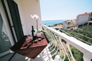 奥米什Villa Brigita的阳台配有带1瓶葡萄酒的桌子。