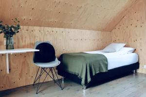 Sandgerði爱思戴小屋酒店的一间卧室配有一张床、一张桌子和一把椅子