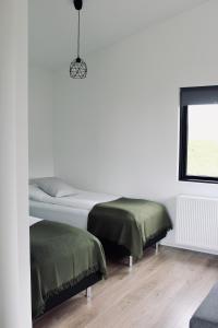 Sandgerði爱思戴小屋酒店的白色的客房设有两张床和窗户。