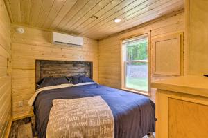布里瓦德Quaint Mtn Cabin Tiny Living Near Big Adventure的小木屋内一间卧室,配有一张床