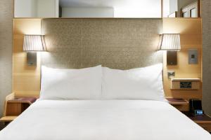伦敦Club Quarters Hotel Covent Garden Holborn, London的一张带白色床单和两盏灯的大床