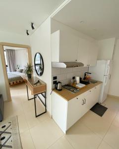 安曼Nu Fifty Two的厨房配有白色橱柜、桌子和床。