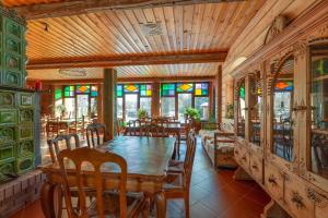 泰里克兹Farma Lama Dom Gościnny的用餐室配有桌椅和彩色玻璃窗