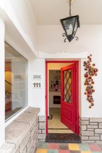 坦迪尔Allegra Dalila Casa Hotel-Arte的商店里一扇红色的门,有窗
