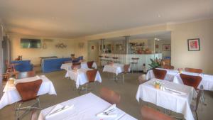 贡迪温迪乡间小路汽车旅馆的餐厅配有桌椅和白色桌布