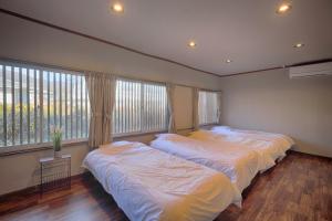 富士河口湖Yoshimura ooike sense的带大窗户的客房内的两张床