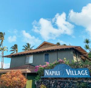 卡哈纳Napili Village Hotel的带有读产村标志的房子