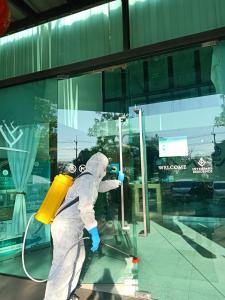 Ban Phan Sadet NokInterpark Hotel & Residence, Eastern Seaboard Rayong的穿着白色衣服洗窗户的人