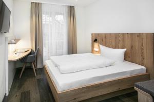 劳芬堡Hotel-Gasthaus Engel Luttingen的一张位于带书桌和床的房间的床铺