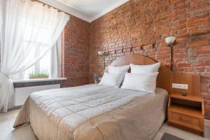 圣彼得堡果戈里之家酒店的一间卧室配有一张砖墙床