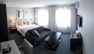 伊丽莎白港Villa Tuscana的一间卧室配有一张床、一张沙发和一个窗口