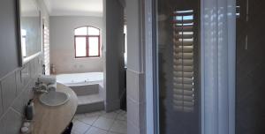 伊丽莎白港Villa Tuscana的浴室配有盥洗盆和浴缸。
