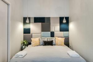 克拉科夫Kings City - Zyblikiewicza 14 apartment的一间卧室配有一张带蓝色和白色床头板的床