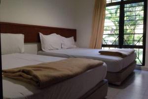 马六甲Villa Mommy A Famosa Resort的一间卧室设有两张床和窗户。