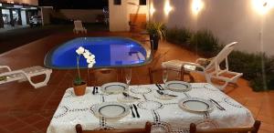 伊瓜苏Pousada Cris Garden Bed&Breakfast的桌椅、桌子和游泳池