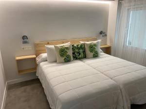拉科萨LM house的卧室配有带绿色枕头的大型白色床