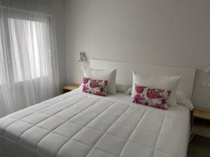 拉科萨LM house的卧室配有带枕头的大型白色床