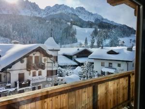 圣坎迪朵Appartements Innerkofler Mountain Home的从阳台可欣赏到积雪覆盖的村庄的景色