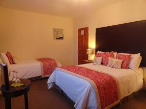 德罗赫达奥利食宿酒店的酒店客房 - 带两张带红色枕头的床