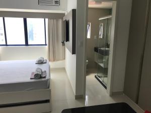 累西腓Studio Everest Flats的一间卧室设有一张床、一个窗口和一间浴室