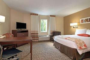 奥兰多MainStay Suites Orlando Altamonte Springs的酒店客房配有一张床、一张书桌和一台电脑