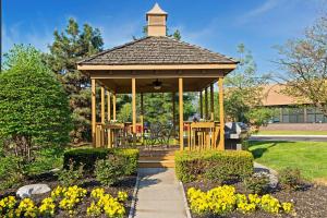 布鲁艾施MainStay Suites Cincinnati Blue Ash的花卉花园中的木制凉亭