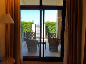 迪拜罗达海滩度假村的阳台设有桌椅,透过窗户可欣赏到风景。