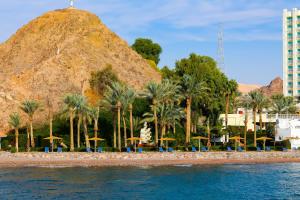 塔巴Steigenberger Hotel & Nelson Village, Taba的享有棕榈树海滩和山脉的美景