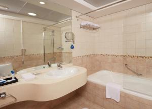 迪拜罗达海滩度假村的浴室配有盥洗盆和浴缸。