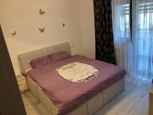 特尔戈维什泰Apartament modern Târgoviște în regim hotelier的一间卧室配有一张带紫色毯子的床