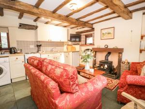 瓦斯代尔下城Stable End Cottage的客厅设有2张红色的沙发和壁炉