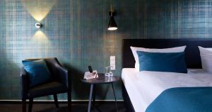 奥尔登堡特瑞德酒店的一间卧室配有一张床、一把椅子和一张桌子
