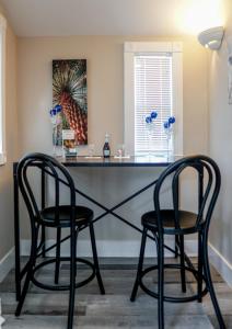 达尼丁Meranova Guest Inn的两个黑椅子坐在一张桌子上,放在一个房间里