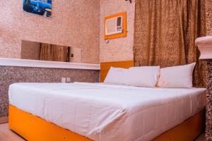 伊凯贾Double One Suites & Lodge的一张带白色床单和枕头的床