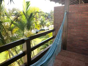 博西坎加Pousada Farol do Marinheiro的棕榈树围栏上的吊床