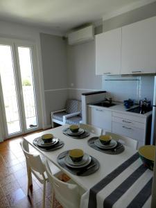 马纳罗拉ARIA DI MARE, Manarola - Appartamento THE VIEW的厨房里设有桌子,上面有盘子和杯子