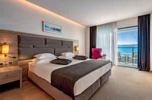 杜埃Hotel Plaža Duće的一间卧室设有一张大床,享有海景