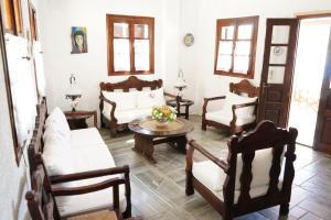 GrikosAlexandros Hotel的客厅配有白色家具和桌子