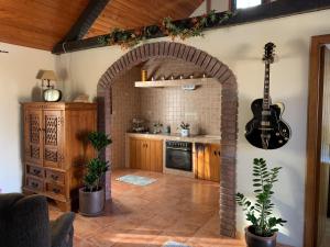蓬特亚雷亚斯Casa Lagar de Arume的厨房里的拱门,墙上有吉他