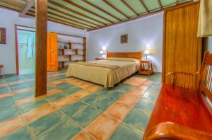 比亚米尔港玛丽塔之屋酒店的卧室配有1张床,铺有瓷砖地板。