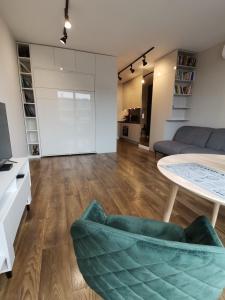 华沙Nowoczesny Apartament z widokiem的客厅配有桌子和沙发